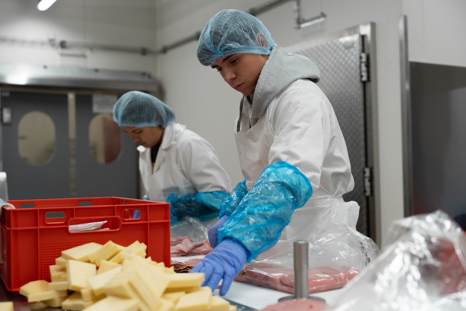 Zwei Mitarbeitende verpacken Fleisch.